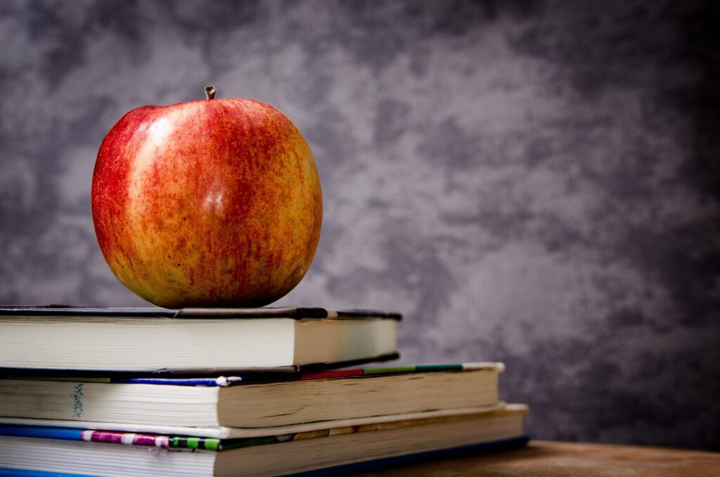 closeup shot of an apple on the book stack